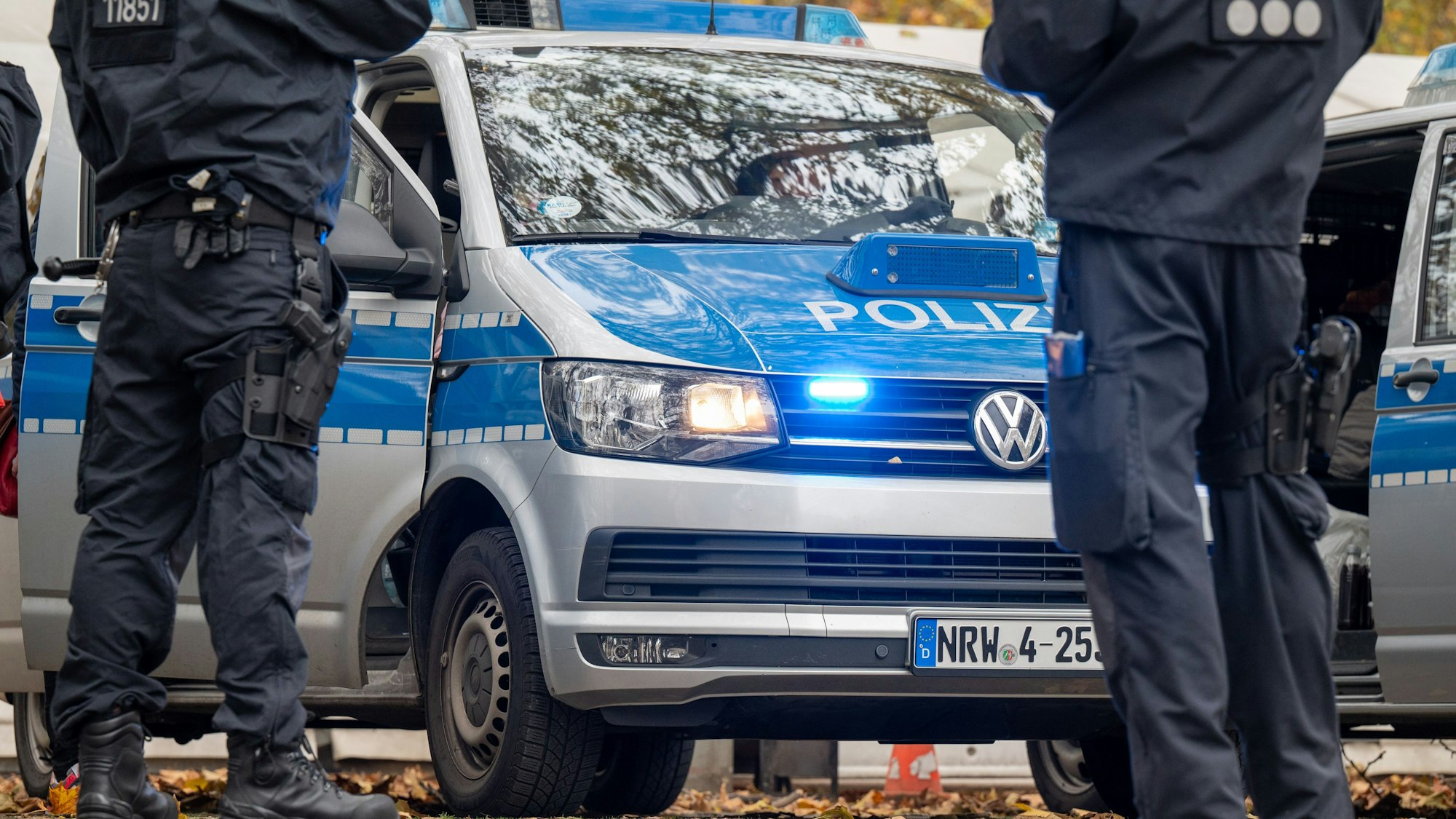 Das Bild zeigt Polizisten und Einsatzfahrzeuge der Polizei.