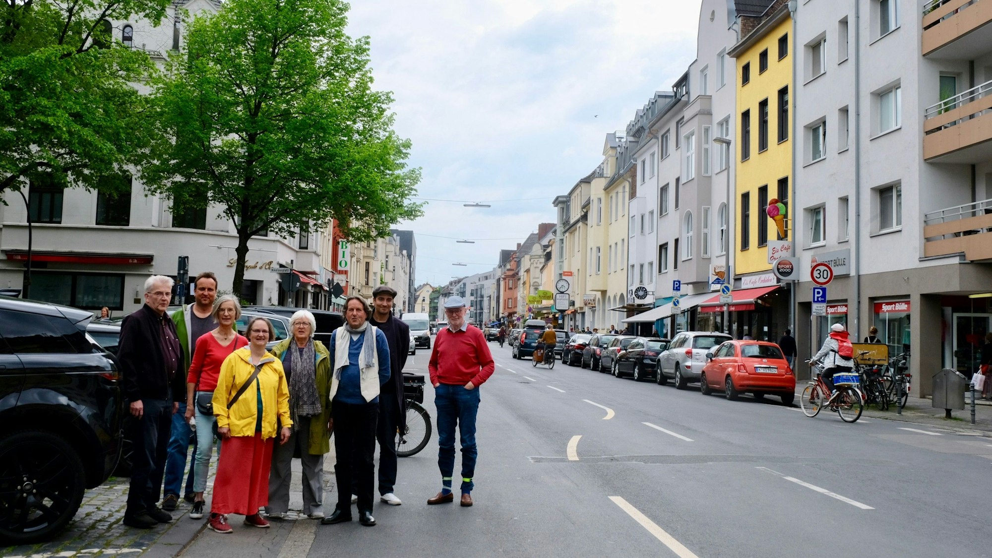 Eine Gruppe Menschen steht am Rand der Berrenrather Straße.
