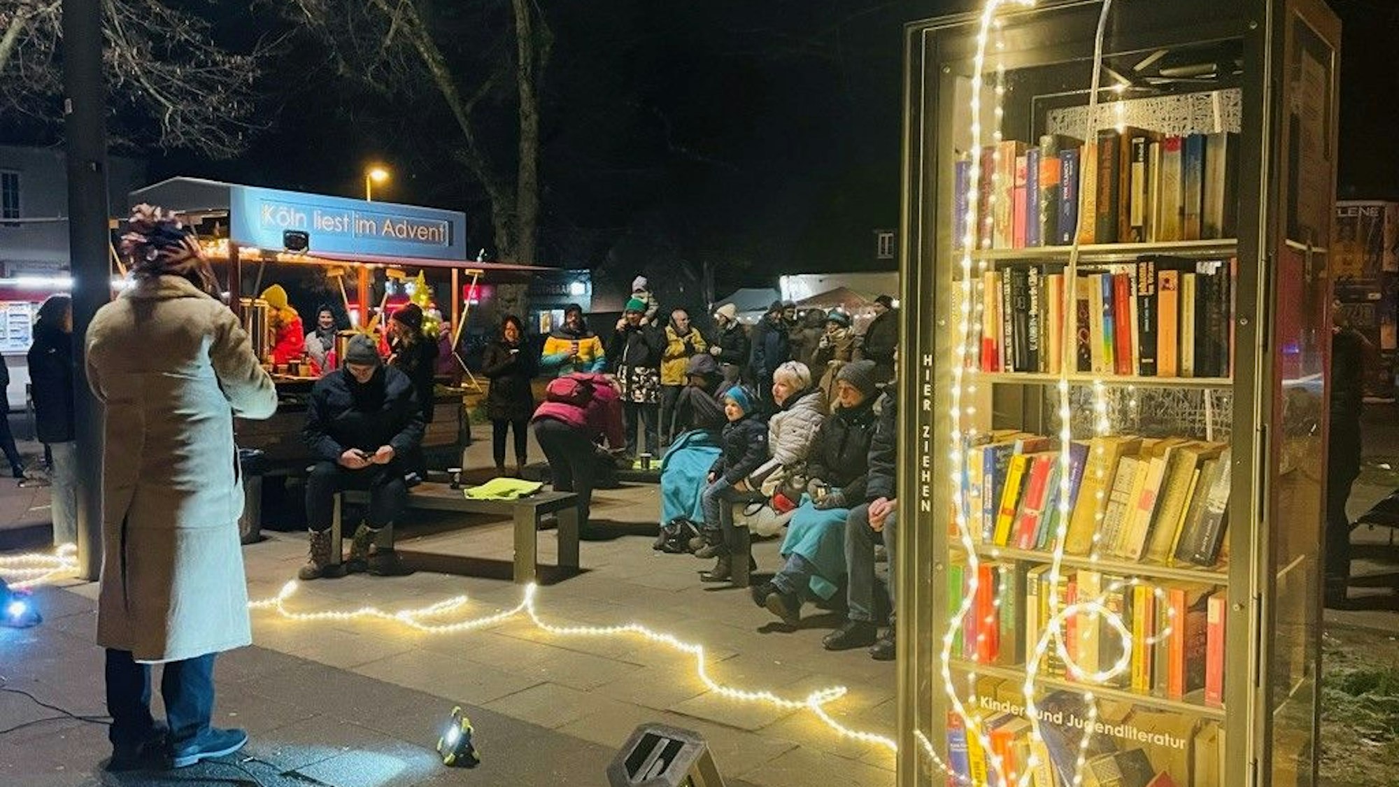 Veranstaltung neben einem beleuchteten Bücherschrank