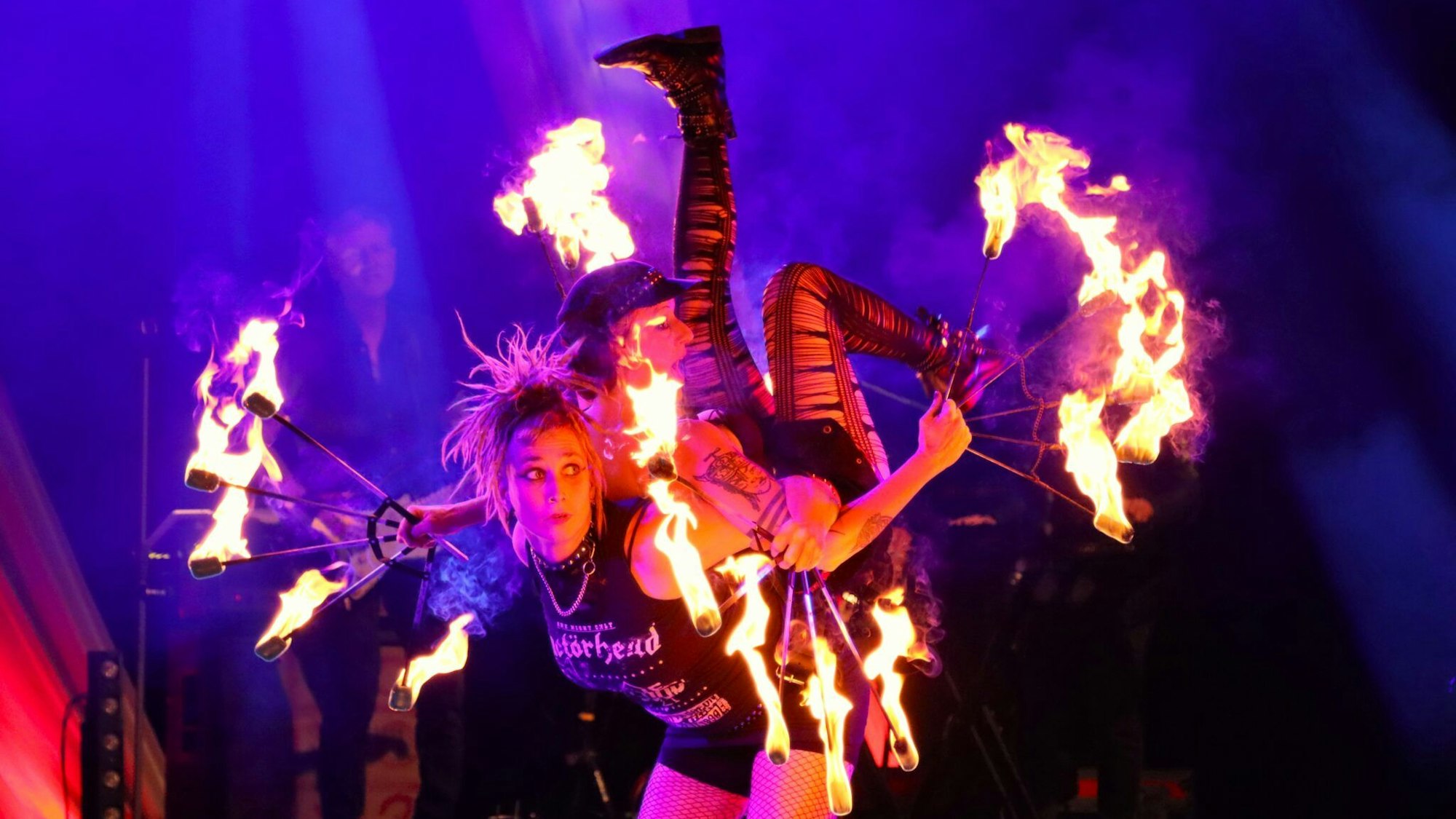 Zwei Frauen jonglieren mit Feuer.