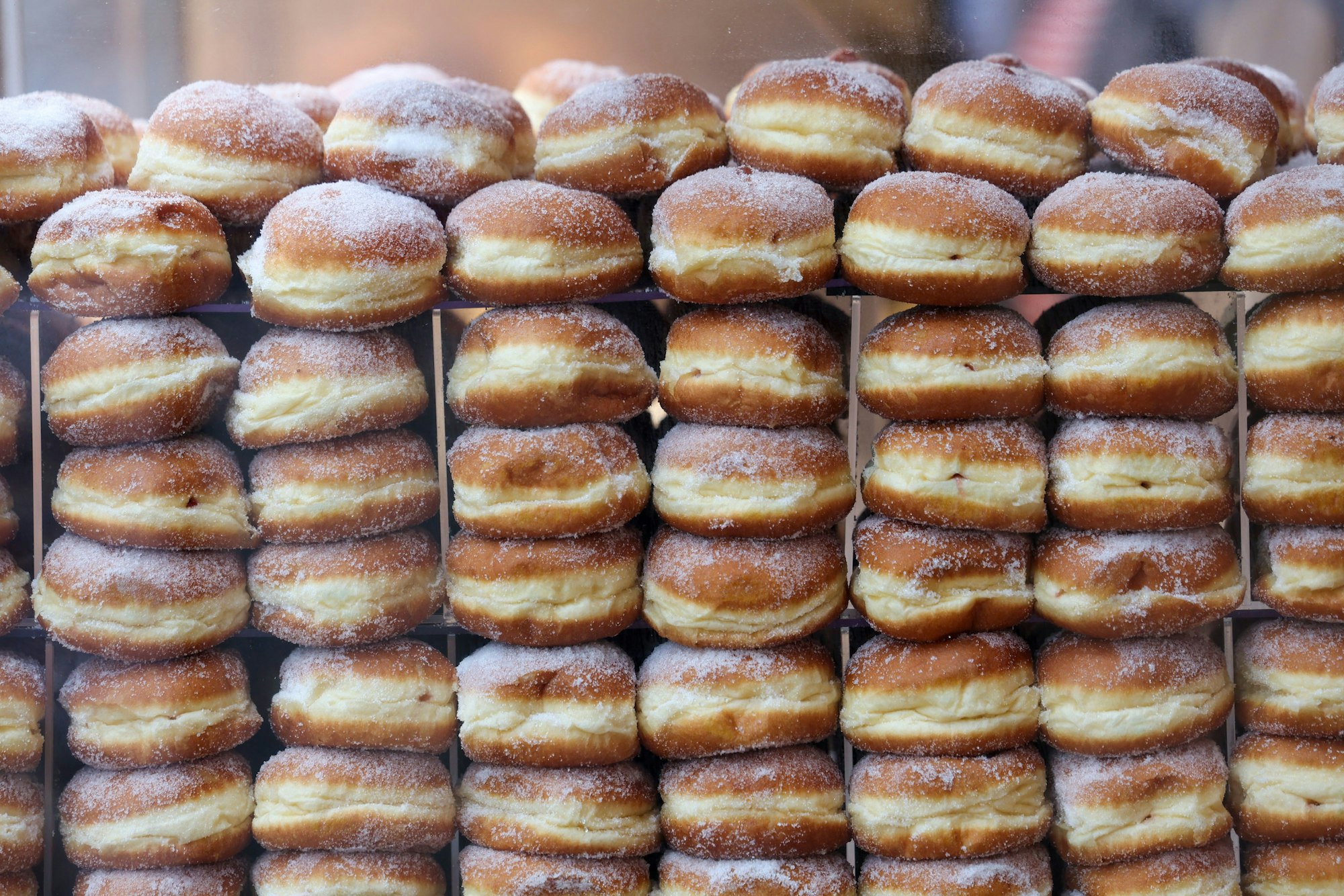 Berliner liegen aufgestapelt in einer Bäckerei.