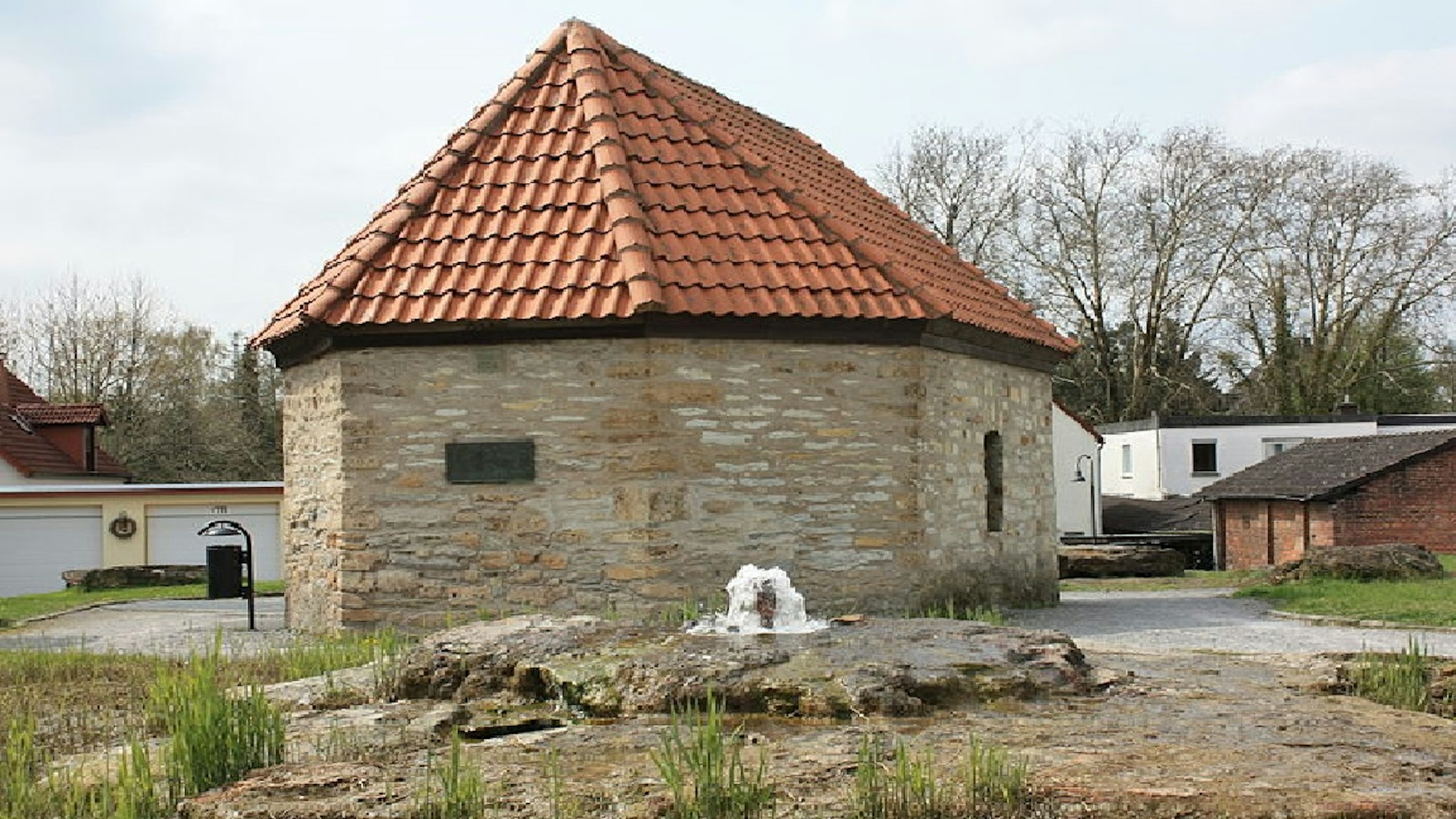 Kleines Gebäude aus Sandstein mit roten Dachziegeln.