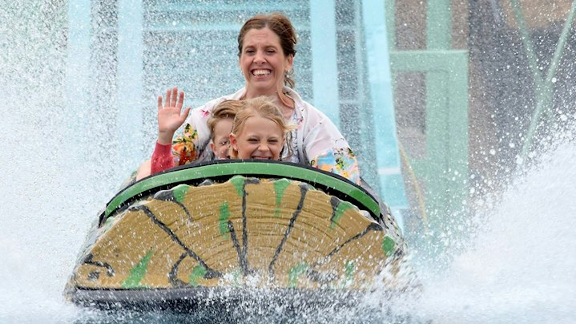 Eine Frau und zwei Kinder fahren auf einer Wasserbahn